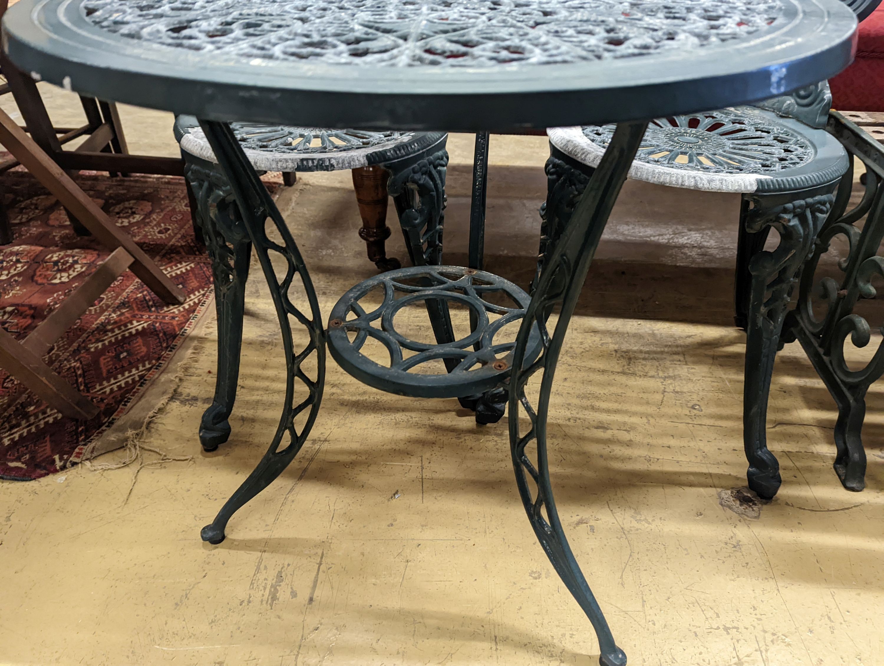 A circular painted aluminium garden table, diameter 60cm, height 62cm together with two chairs